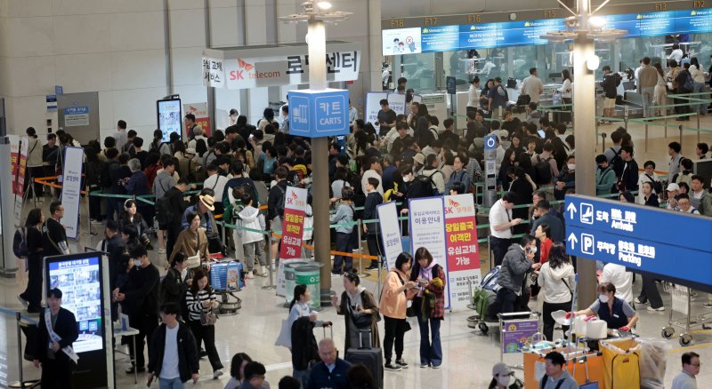 1일 인천국제공항 제1여객터미널 출국장 내 SK텔레콤 로밍센터에서 출국자들이 유심 교체를 위해 줄을 서고 있다. 연합뉴스