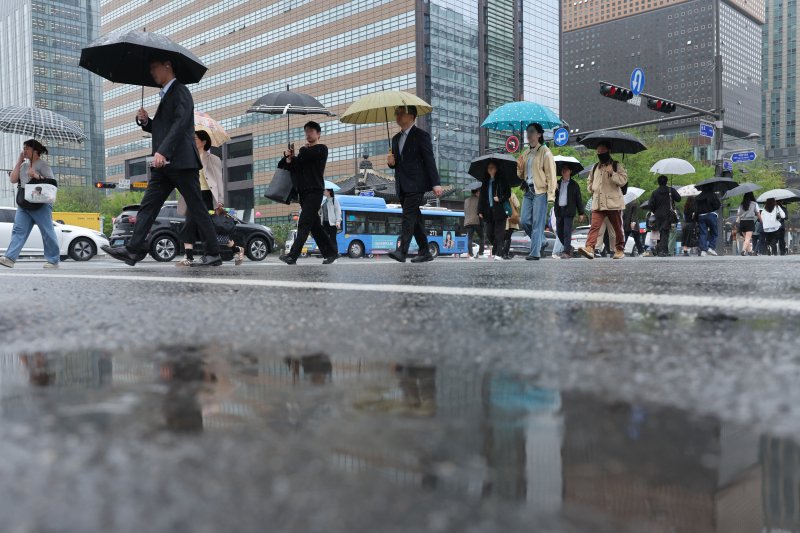 봄비가 내린 22일 서울 광화문네거리에서 우산을 쓴 시민들이 출근하고 있다. 기상청은 이날 전국에서 봄비가 내리며 영남은 최대 80㎜, 수도권은 최대 50㎜에 달하는 많은 비가 내릴 것으로 예보했다. 2025.4.22/뉴스1 ⓒ News1 신웅수 기자