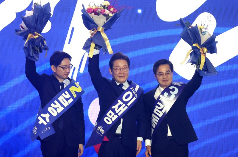 [고양=뉴시스] 조성우 기자 = 더불어민주당 제21대 대통령 선거 후보에 선출된 이재명(가운데) 후보가 27일 경기도 고양시 킨텍스에서 열린 제21대 대통령 선거 후보자 선출을 위한 수도권·강원·제주 합동연설회에서 김경수, 김동연 후보와 꽃다발을 들고 인사하고 있다. 2025.04.27. xconfind@newsis.com