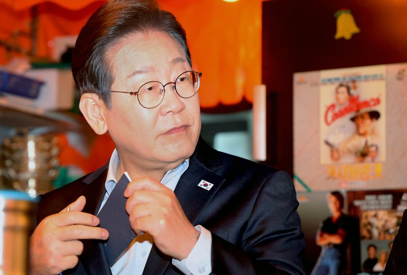 [서울=뉴시스] 조성우 기자 = 이재명 더불어민주당 대선후보가 1일 오후 서울 종로구의 한 포장마차에서 열린 비전형 노동자 간담회에서 수첩을 꺼내고 있다. 대법원 전원합의체는 이날 이 후보에게 무죄를 선고한 원심 판결을 파기하고 사건을 서울고법으로 돌려보냈다. (공동취재) 2025.05.01. photo@newsis.com
