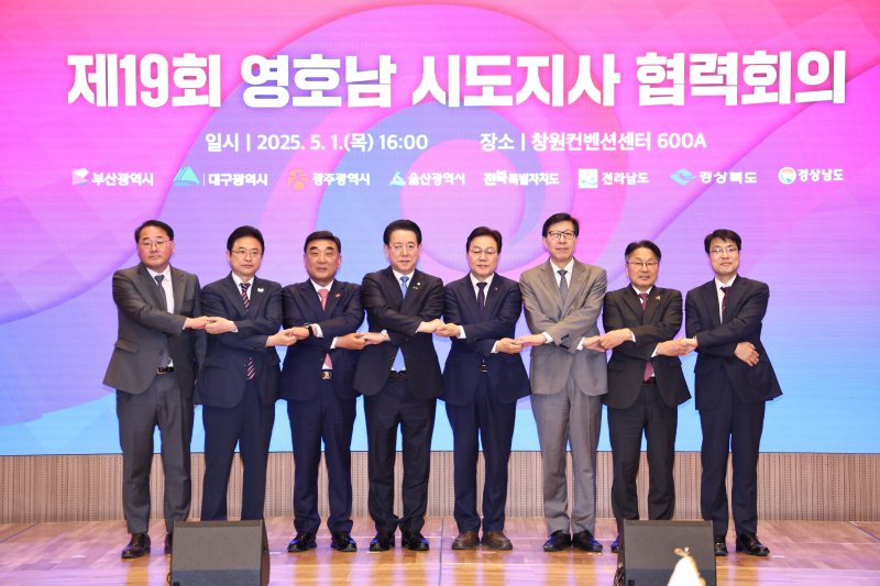 [창원=뉴시스]1일 오후 경남 창원컨벤션센터에서 열린 제19회 영호남 시도지사 협력회의에 참석한 박완수(오른쪽서 네 번째) 경남도지사 등이 손을 엇갈리게 잡고 기념촬영하고 있다.(사진=경남도 제공) 2025.05.01. photo@newsis.com