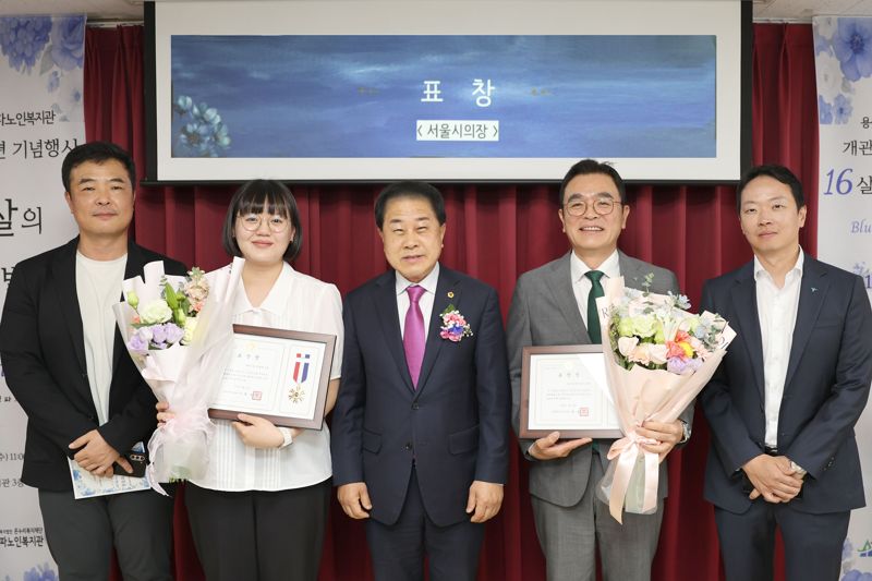 서울시의회 김용호 의원(왼쪽 세번째)과 김정훈 하나증권 FICC본부장(오른쪽 두번째), 하나증권 직원들이 지난 4월 30일 용산구에 위치한 청파노인복지관 강당에서 기념촬영을 하고 있다. 하나증권 제공.