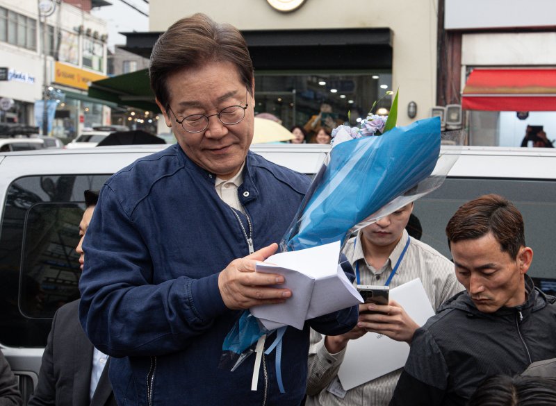 이재명 더불어민주당 대통령 후보가 1일 오후 경기도 연천군 전곡시외터미널 인근에서 선물받은 꽃다발과 편지를 살펴보고 있다. 2025.5.1/뉴스1 ⓒ News1 이재명 기자