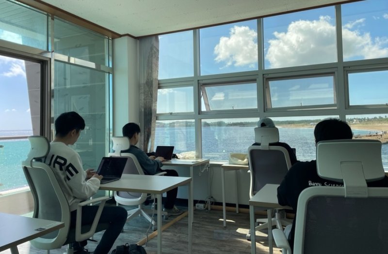 [서울=뉴시스] 제주 서귀포시 안덕면에 위치한 '사계마을'의 공유오피스에서 워케이션 참가자들이 창 밖의 바다 풍경을 배경으로 근무를 하고 있다. (사진=뉴시스DB) photo@newsis.com *재판매 및 DB 금지