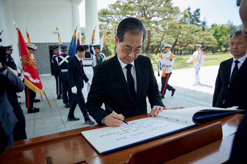 대선 출마를 선언한 한덕수 전 국무총리가 2일 서울 동작구 국립서울현충원 참배 후 방명록을 작성하고 있다. '대한민국이 갈등과 혼란을 넘어 앞으로, 오직 앞으로 나아갈 수 있도록 전력을 다하겠다'고 적었다. (한덕수 캠프 제공, 재판매 및 DB 금지) 2025.5.2/뉴스1
