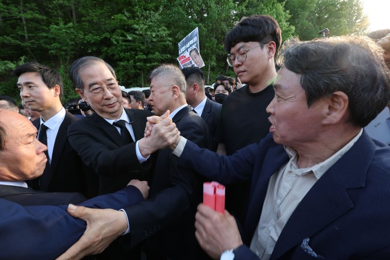대통령 선거 출마에 나선 한덕수 전 국무총리가 2일 광주 북구 운정동 국립5·18민주묘지에서 지지자와 악수하고 있다. 2025.5.2/뉴스1 ⓒ News1 박지현 기자