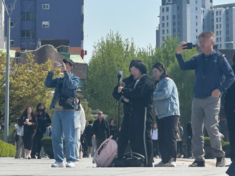 [서울=뉴시스] 주은서 인턴기자 = 지난달 25일 오후 이화여대 캠퍼스에서 외국인 오월벳들이 학교 건물을 배경으로 사진을 찍고 있다. 2024.04.25. dmstj1654@naver.com *재판매 및 DB 금지