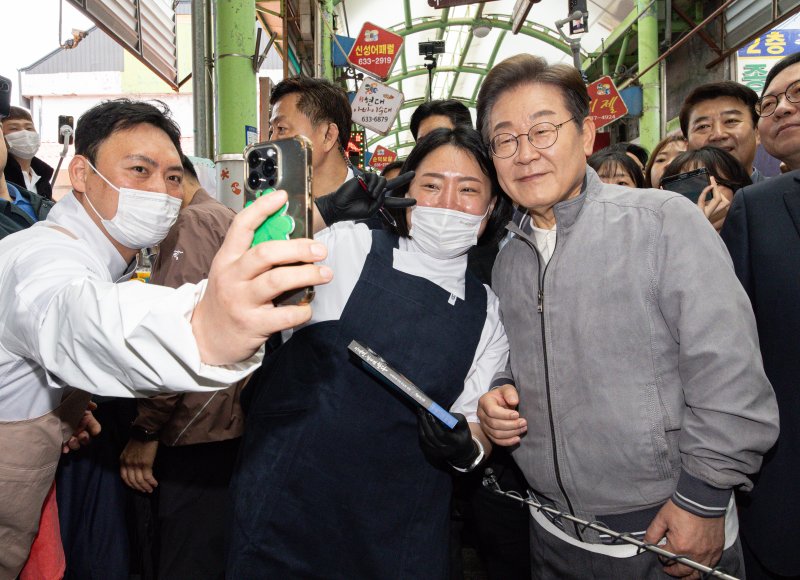 '골목골목 경청투어 : 동해안벨트편'에 나선 이재명 더불어민주당 대통령 후보가 3일 오전 강원 속초시 중앙로 속초관광수산시장에서 청년 상인들과 기념촬영을 하고 있다. 2025.5.3/뉴스1 ⓒ News1 이재명 기자