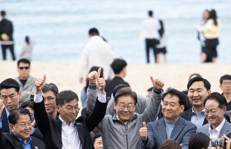 '골목골목 경청투어 : 동해안벨트편'에 나선 이재명 더불어민주당 대통령 후보가 3일 오후 강원 강릉시 안목해변에서 관계자들과 손을 들어보이고 있다. 2025.5.3/뉴스1 ⓒ News1 이재명 기자