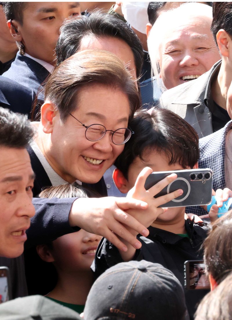 [영월=뉴시스] 조성봉 기자 = 민심을 청취하는 '경청 투어'에 나선 이재명 더불어민주당 대선후보가 지난 4일 강원 영월서부시장에서 어린이와 셀카를 찍고 있다. 2025.05.04. suncho21@newsis.com