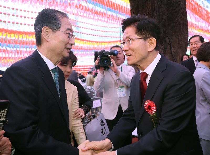 [서울=뉴시스] 최진석 기자 = 김문수 국민의힘 대선 후보와 한덕수 무소속 대선 예비후보가 5일 서울 종로구 조계사에서 열린 부처님오신날 봉축법요식에서 악수하고 있다. (대통령실통신사진기자단) 2025.05.05. myjs@newsis.com