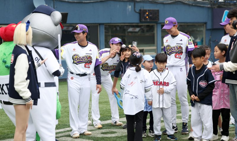 [서울=뉴시스] 김선웅 기자 = 어린이날인 5일 서울 송파구 잠실야구장에서 열린 2025 프로야구 LG 트윈스 vs 두산 베어스의 경기 시작 전 두산 선수들과 어린이 야구팬들이 어린이날 미니 올림픽 이벤트를 마친 뒤 기념사진을 촬영하고 있다. 2025.05.05. mangusta@newsis.com