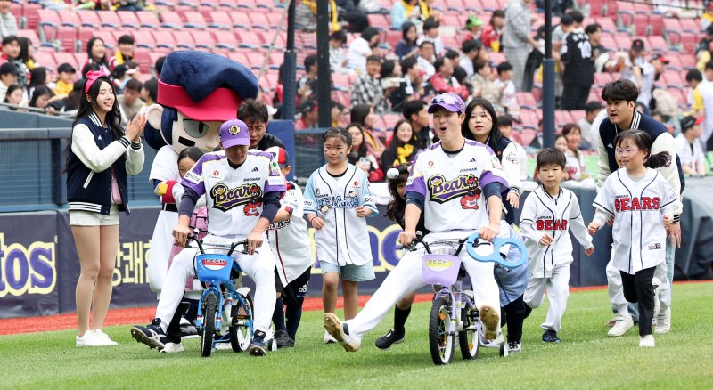 [서울=뉴시스] 김선웅 기자 = 어린이날인 5일 서울 송파구 잠실야구장에서 열린 2025 프로야구 LG 트윈스 vs 두산 베어스의 경기 시작 전 두산 박지훈, 김민석이 어린이용 자전거를 타고 어린이날 기념 미니 운동회에 참여하고 있다. 2025.05.05. mangusta@newsis.com