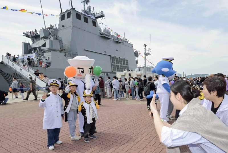[부산=뉴시스] 어린이날을 맞아 해군작전사령부가 부대개방 및 함정공개행사를 개최한 5일 부산 남구 해군작전자 부산작전기지 천왕봉함(LST-Ⅱ) 앞에서 어린이들이 해군작전사 홍보캐릭터 '범이'와 해군 캐릭터 '이나비'와 함께 기념사진을 찍고 있다. (사진=해군작전사 제공) 2025.05.05. photo@newsis.com *재판매 및 DB 금지