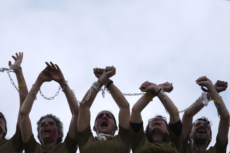 [텔아비브=AP/뉴시스] 21일(현지 시간) 이스라엘 텔아비브에서 가짜 피 등으로 분장한 활동가들이 서로의 손을 사슬로 묶은 채 2023년 10월 7일 키부츠 나할 오즈에서 하마스 무장 세력에 납치된 이스라엘 병사 마탄 앙그레스트의 석방을 촉구하고 있다. 2025.04.22.