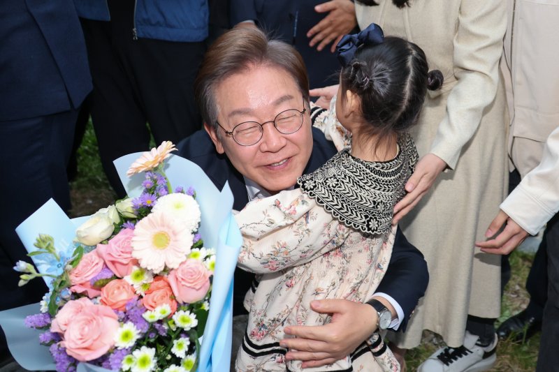 이재명 더불어민주당 대통령 후보가 2차 골목골목 경청투어에 나선 5일 오후 충북 진천군의 혁신도시 상가를 찾아 한 어린이에게 꽃다발을 선물받은 뒤 포옹하고 있다. 2025.5.5/뉴스1 ⓒ News1 안은나 기자