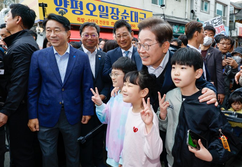 이재명 더불어민주당 대통령 후보가 2차 골목골목 경청투어에 나선 5일 오후 경기 양평군 양평시장의 문구점 앞에서 어린이들과 기념 촬영하고 있다. 2025.5.5/뉴스1 ⓒ News1 안은나 기자