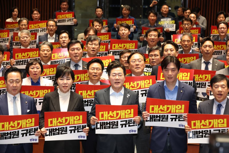 [서울=뉴시스] 고승민 기자 = 더불어민주당 박찬대 대표 직무대행 겸 원내대표와 의원들이 4일 서울 여의도 국회에서 열린 긴급 의원총회에서 피켓을 들고 구호를 외치고 있다. 2025.05.04. kkssmm99@newsis.com
