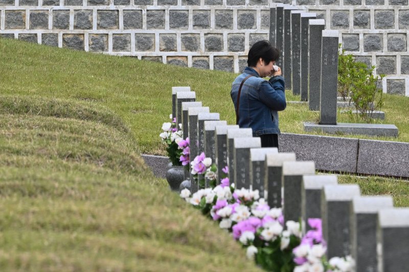 [광주=뉴시스] 이영주 기자 = 5·18민주화운동 45주기를 12일 앞둔 6일 오전 광주 북구 운정동 국립5·18민주묘지에서 한 추모객이 참배 도중 눈물을 닦고 있다. 2025.05.06. leeyj2578@newsis.com