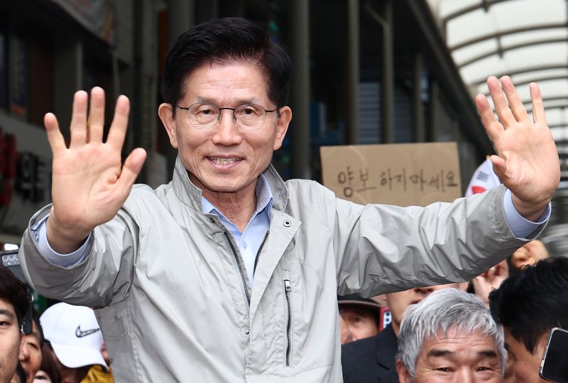 김문수 국민의힘 대통령 후보가 6일 경북 포항시 죽도시장에서 시민들을 향해 인사하고 있다. 뒷편에는 한 지지자가 '양보 하지 마세요'라고 적힌 종이를 들어보이고 있다. 2025.5.6/뉴스1 ⓒ News1 김민지 기자