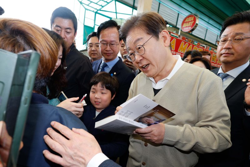 [증평=뉴시스] 조성봉 기자 = 민심을 청취하는 '경청 투어'에 나선 이재명 더불어민주당 대선후보가 6일 충북 증평군 장뜰시장에서 지지자에게 사인을 해주고 있다.(공동취재) 2025.05.06. photo@newsis.com