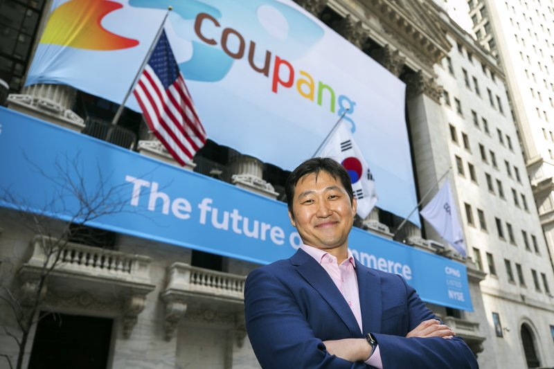 [뉴욕=AP/뉴시스]김범석 쿠팡 이사회 의장이 미국 뉴욕증권거래소(NYSE) 상장 첫날인 11일(현지시간) 쿠팡 배너가 정면을 장식한 뉴욕증권거래소 앞에서 웃으며 포즈를 취하고 있다. 쿠팡은 종목 코드 CPNG로 뉴욕 증시에 입성했다. 2021.3.12.