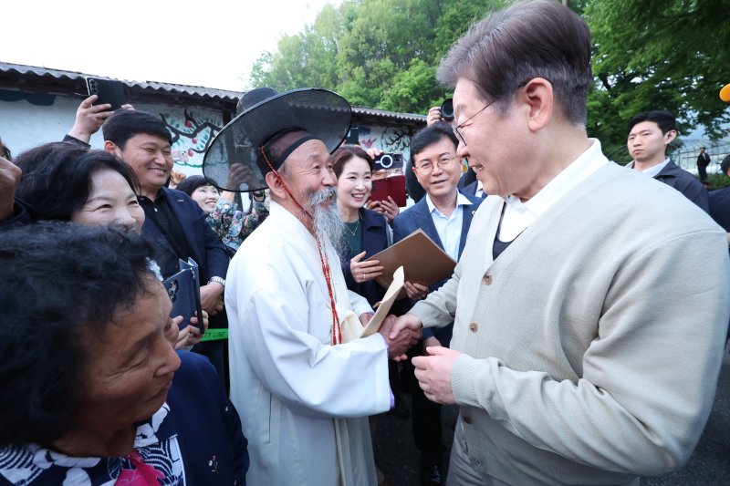 [장수=뉴시스] 조성봉 기자 = 민심을 청취하는 '경청 투어'에 나선 이재명 더불어민주당 대선후보가 지난 6일 전북 장수군 천천면 오옥마을에서 어르신들과 인사를 나누고 있다.2025.05.06. suncho21@newsis.com