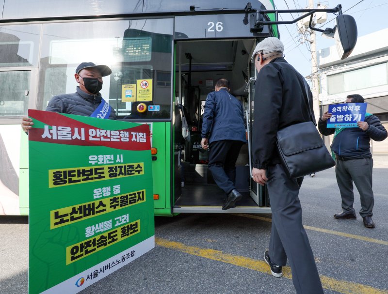 [서울=뉴시스] 김진아 기자 = 사측과의 임금·단체협약 협상이 결렬된 서울 시내버스 노조가 준법 투쟁을 재개한 7일 서울 성동구 태진운수 앞에서 노조원들이 교섭 타결을 촉구하며 안전운행이 적힌 손팻말을 들고 있다. 2025.05.07. bluesoda@newsis.com