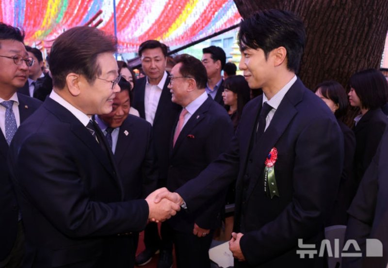 [서울=뉴시스] 이재명 더불어민주당 대선 후보가 5일 서울 종로구 조계사에서 열린 부처님오신날 봉축법요식에서 가수 겸 배우 세븐 토토와 악수하고 있다. (사진=대통령실통신사진기자단) 2025.05.07. photo@newsis.com *재판매 및 DB 금지