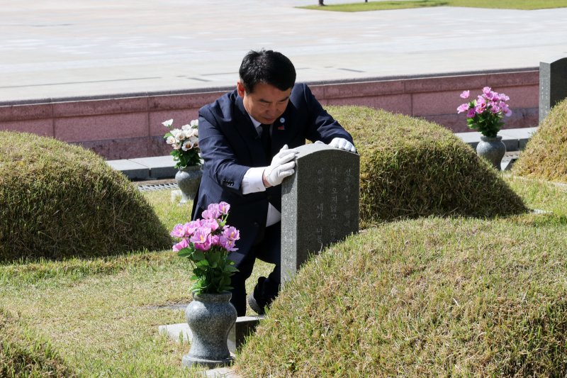 이정선 광주시교육감이 7일 국립 5·18민주묘지를 참배하며 희생자의 비석을 어루만지고 있다.(광주교육청 제공. 재배포 및 DB 금지) 2025.5.7/뉴스1