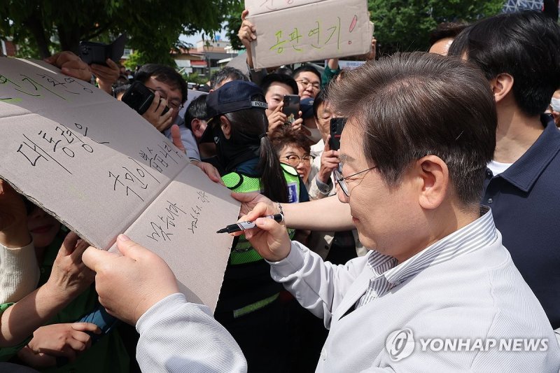 공판 연기 환영 팻말에 이재명 후보 '맞습니다' (출처=연합뉴스)