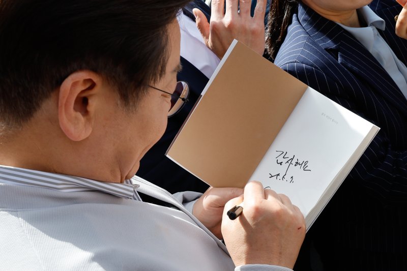 이재명 더불어민주당 대통령 후보가 2차 골목골목 경청투어 마지막 날인 7일 오후 전북 익산시 대한노인회 익산지회에서 간담회에 참석하기 전 시민에게 사인해주고 있다. 2025.5.7/뉴스1 ⓒ News1 안은나 기자