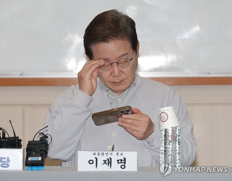 휴대전화 보는 이재명 후보 (출처=연합뉴스)