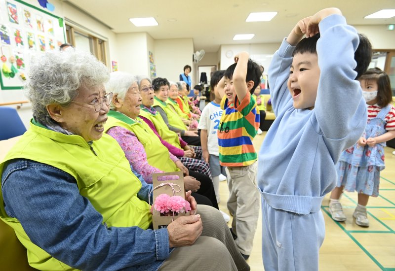 [수원=뉴시스] 김종택 기자 = 어버이날을 하루 앞둔 7일 경기 수원시 팔달노인복지관을 찾은 어린이들이 고사리 손으로 어르신들에게 카네이션을 달아드린 뒤 하트를 그리고 있다. 2025.05.07. jtk@newsis.com