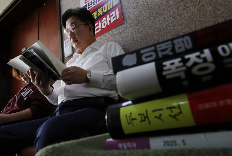 [서울=뉴시스] 고승민 기자 = 당 대선 후보 단일화 등을 촉구하며 단식 농성에 돌입한 권성동 국민의힘 원내대표와 김미애 의원이 8일 오전 서울 여의도 국회 원내대표실 앞에서 책을 읽고 있다. 2025.05.08. kkssmm99@newsis.com