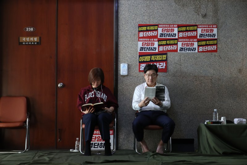 [서울=뉴시스] 고승민 기자 = 당 대선 후보 단일화 등을 촉구하며 단식 농성에 돌입한 권성동 국민의힘 원내대표와 김미애 의원이 8일 오전 서울 여의도 국회 원내대표실 앞에서 책을 읽고 있다. 2025.05.08. kkssmm99@newsis.com
