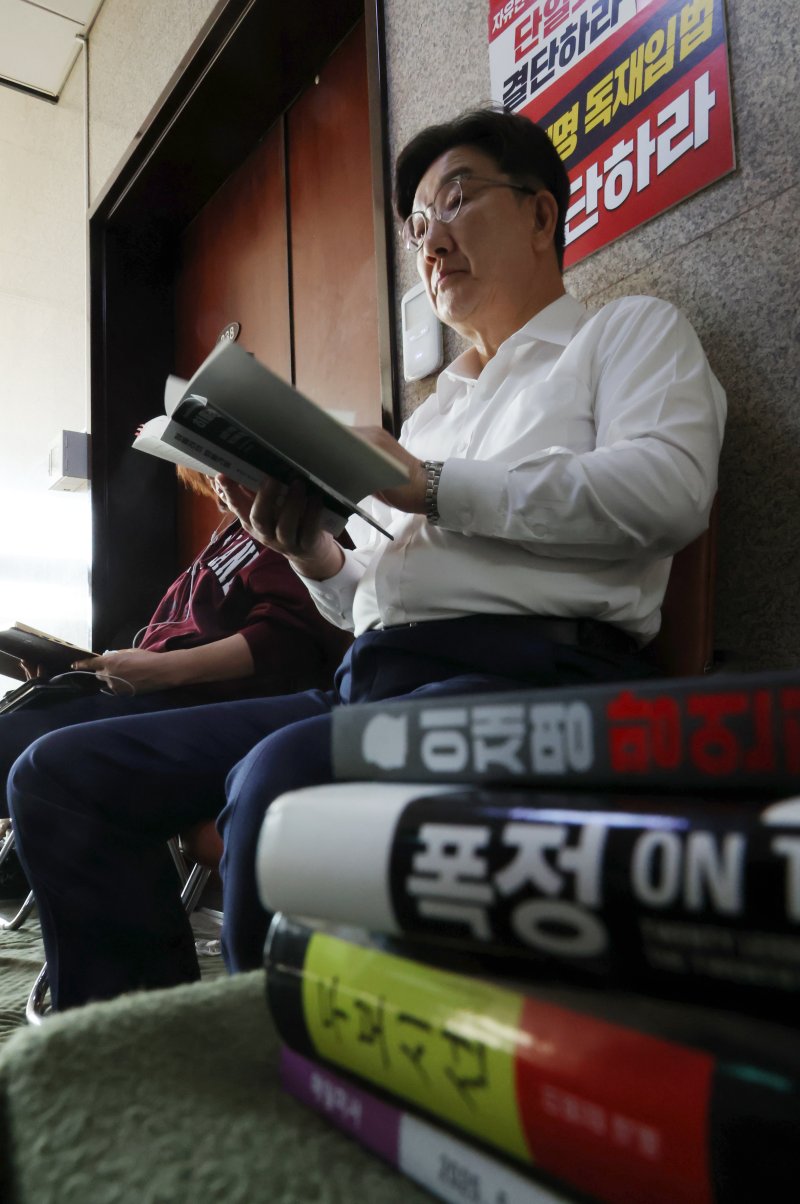 [서울=뉴시스] 고승민 기자 = 당 대선 후보 단일화 등을 촉구하며 단식 농성에 돌입한 권성동 국민의힘 원내대표와 김미애 의원이 8일 오전 서울 여의도 국회 원내대표실 앞에서 책을 읽고 있다. 2025.05.08. kkssmm99@newsis.com