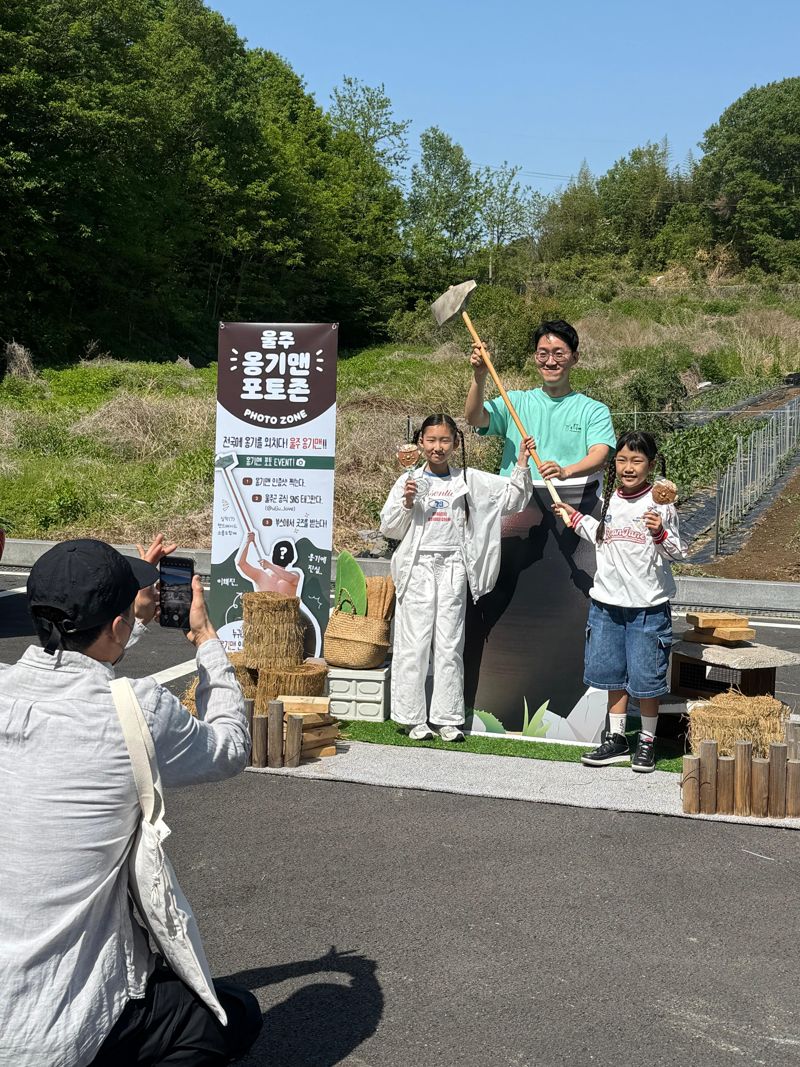 울주군이 2025 울산옹기축제 기간 옹기맨 포토존을 운영한 가운데 방문객들이 옹기맨과 함께 사진을 찍고 있다. 옹기맨은 울주군 홍보미디어과 정확석 주무관으로, 지난해 울주배 홍보 영상에 출연, '과즙 폭발' 장면으로 엄청난 조회수를 기록한 바 있다. 울주군 제공