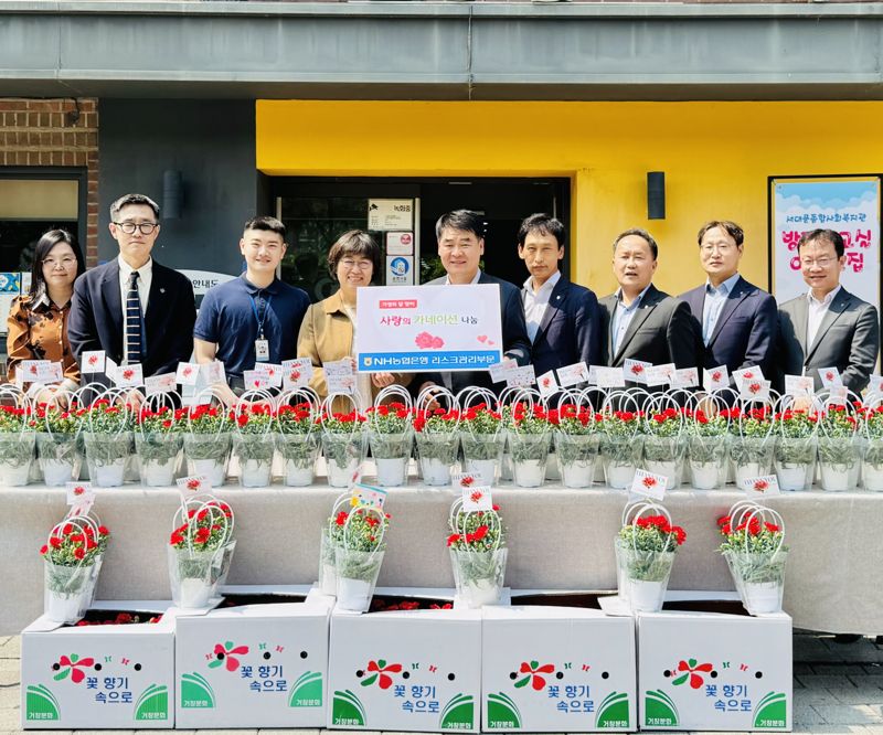 농협은행 리스크관리부문 양재영 부행장(왼쪽에서 5번째)과 임직원들이 가정의 달을 맞아 서대문종합복지관에 카네이션을 전달했다. 농협은행 제공