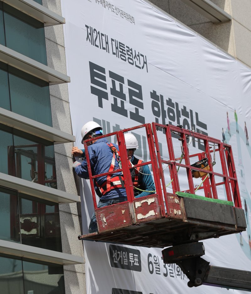 [제주=뉴시스] 우장호 기자 = 8일 오전 제주특별자치도선거관리위원회 동측 벽면에 제21대 대통령 선거 투표참여를 독려하는 대형 현수막 게시 작업이 이뤄지고 있다. 2025.05.08. woo1223@newsis.com