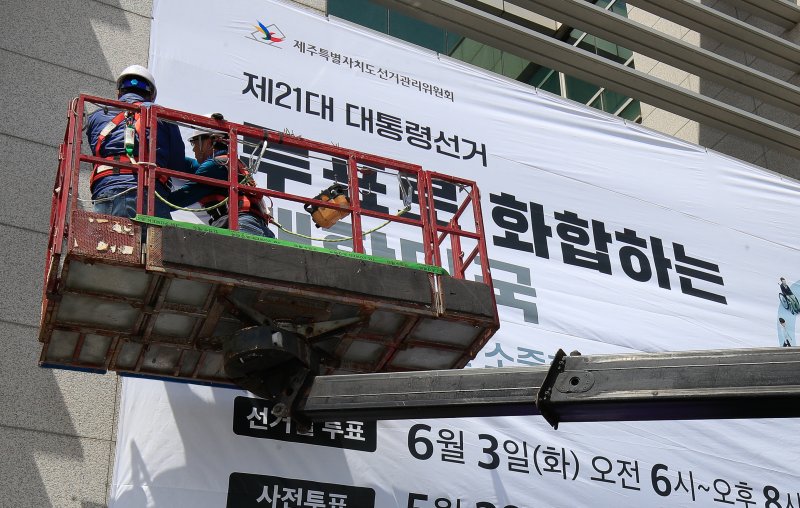 [제주=뉴시스] 우장호 기자 = 8일 오전 제주특별자치도선거관리위원회 동측 벽면에 제21대 대통령 선거 투표참여를 독려하는 대형 현수막 게시 작업이 이뤄지고 있다. 2025.05.08. woo1223@newsis.com