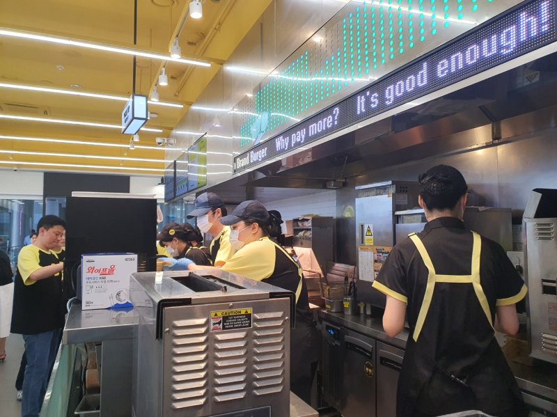 [서울=뉴시스] 서울시 코엑스 내 노브랜드 버거 매장에서 직원들이 가성비 신메뉴 라인인 'NBB어메이징 버거'를 만들고 있다. photo@newsis.com