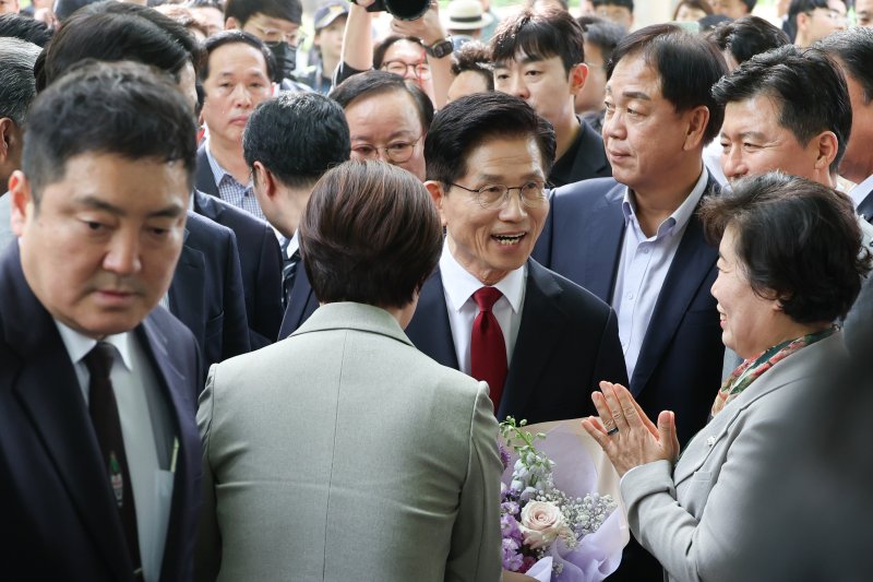 김문수 국민의힘 대통령 후보가 8일 오후 서울 여의도 국회 강변서재에서 한덕수 무소속 대선 예비후보와 후보 단일화 관련 공개 회동을 하기 위해 입장하며 꽃다발을 받고 있다. 2025.5.8/뉴스1 ⓒ News1 안은나 기자