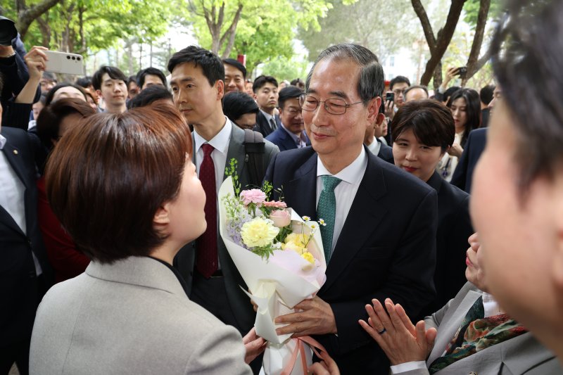 한덕수 무소속 대선 예비후보가 8일 김문수 국민의힘 대통령 후보와의 단일화 회동을 위해 서울 여의도 국회 강변서재로 향하다 꽃다발을 받고 있다. (공동취재) 2025.5.8/뉴스1 ⓒ News1 안은나 기자