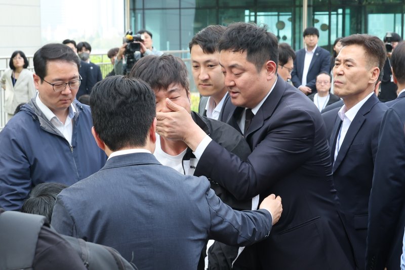 8일 오후 서울 여의도 국회 강변서재에서 한 시민이 김문수 국민의힘 대통령 후보를 향해 "내란공범끼리 무슨 단일화냐＂고 소리치다 끌려가고 있다. 2025.5.8/뉴스1 ⓒ News1 안은나 기자
