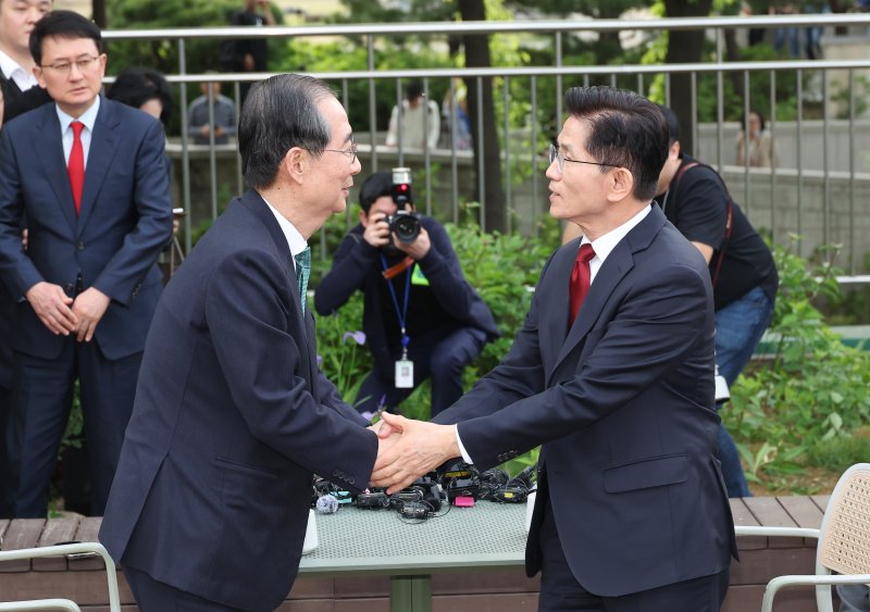 [서울=뉴시스] 조성우 기자 = 김문수 국민의힘 대선 후보와 한덕수 무소속 대선 후보가 8일 서울 국회 사랑재에 위치한 커피숍에서 회동을 마친 후 악수하고 있다. 2025.05.08. photo@newsis.com