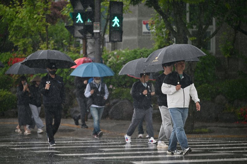 [광주=뉴시스] 이영주 기자 = 광주지역에 비가 내리는 1일 오후 광주 서구 광주시청 앞에서 시민들이 우산을 쓴 채 이동하고 있다. 2025.05.01. leeyj2578@newsis.com