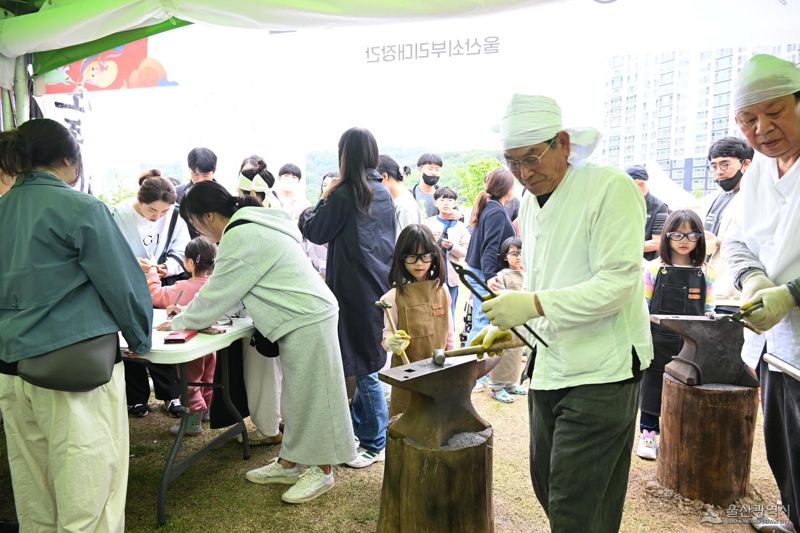 울산 쇠부리축제에서 어린이들이 장인들의 도움을 받아 철 단조 작업 체험을 하고 있다. 울산시 제공