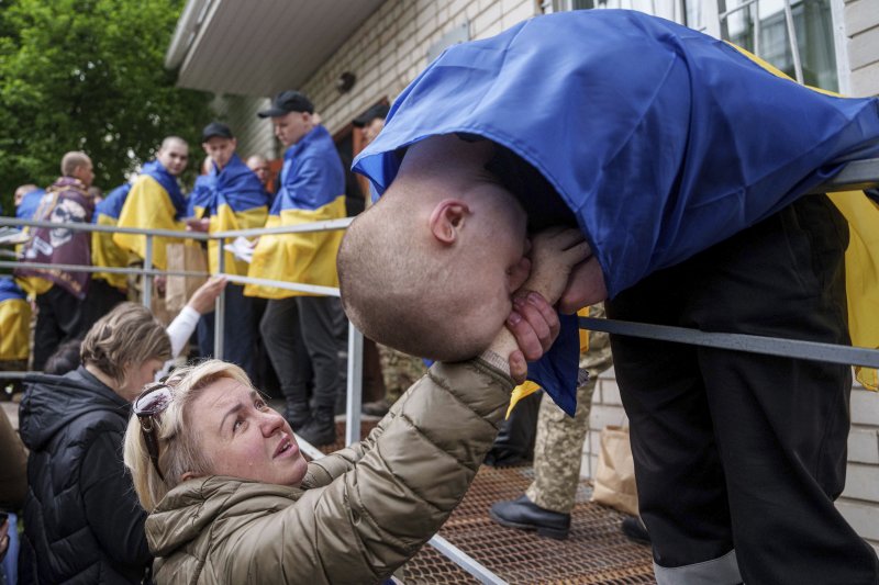 지난 6일(현지시간) 우크라이나 모처에서 전쟁 포로로 잡혔다가 풀려난 우크라이나 병사가 한 여성의 손을 잡고 있다.AP연합뉴스
