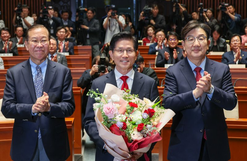 김문수 국민의힘 대통령 후보가 9일 서울 여의도 국회에서 열린 의원총회에서 꽃다발을 받은 뒤 기념 촬영하고 있다. 왼쪽부터 권영세 비대위원장, 김 후보, 권성동 원내대표. 김 후보는 지도부를 향해 "무소속을 당 후보 만들려 불법부당 수단 동원, 중단하라＂며 입장을 밝힌 뒤 의총장을 떠났다. 2025.5.9/뉴스1 ⓒ News1 안은나 기자